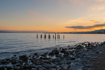 Wall Mural - Ruins of wooden pier in the beach sea and sky with sunset light