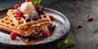 belgian waffles with ice cream and fresh berries. close up square waffles with raspberries blueberries blackberries and caramel syrup, side view