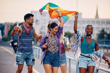 Wall Mural - Multiracial group of cheerful people with LGBT flag having fun on street.