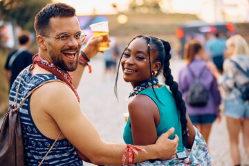 Wall Mural - Cheerful multiracial couple going on summer music festival and looking at camera.