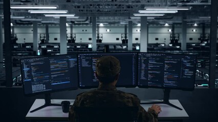 Back View Of Asian Military Having Headache While Write Code With Multiple Computer Screens In Data Center