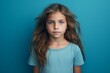 Portrait of a little girl with long hair on a blue background