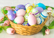Easter holiday celebration banner; greeting card; Close up for easter eggs in a wicker basket on a white background