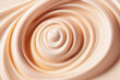 Liquid creamy texture swirled background. Close-up of a delicate soft beige color flowing circular effect on the surface of a cosmetic product.