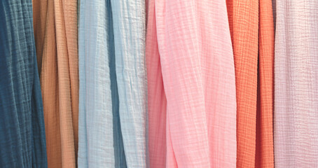 Poster - Multi-colored textile fabrics hang in a market or store as an abstract background