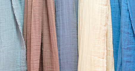Poster - Multi-colored textile fabrics hang in a market or store as an abstract background