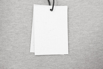 Poster - Cardboard tags on brown garment, top view. Space for text