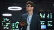 © stockbusters - Serious IT specialist working tablet in data center closeup. Man looking asides