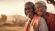 An elderly couple shares a heartfelt embrace, smiling joyfully in a warm, sunlit outdoor setting.
