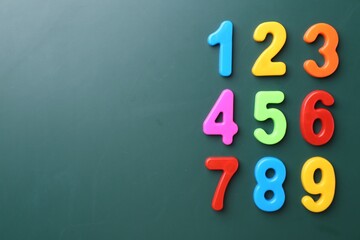 Poster - Colorful numbers on green background, flat lay. Space for text