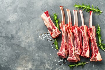 Wall Mural - Raw Lamb Ribs and Herbs Ready for the Grill on Slate Background