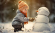 Cute little boy is building an amazing snowman.