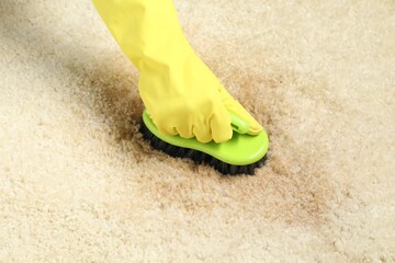 Canvas Print - Woman removing stain from beige carpet, closeup