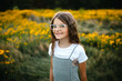 © Maria Manco/Stocksy - Preteen smiles at camera in wildflower field