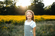 © Maria Manco/Stocksy - Preteen smiles at camera in wildflower field