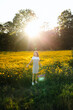 © Maria Manco/Stocksy - Preteen smiles at camera in wildflower field