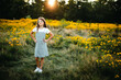 © Maria Manco/Stocksy - Preteen smiles at camera in wildflower field