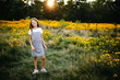 © Maria Manco/Stocksy - Preteen smiles at camera in wildflower field