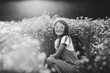 © Maria Manco/Stocksy - Preteen smiles at camera in wildflower field