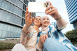 © Santi Nuñez/Stocksy - Portrait of happy muslim women friends making selfie together