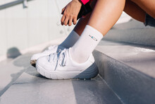 Crop Tanned Woman White Shoes And Socks On Outdoor Stairs In Summer
