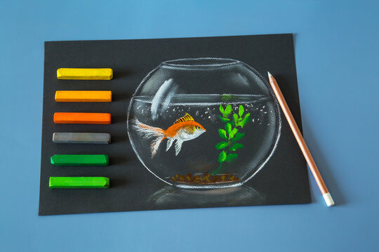 Soft pastel painting of gold fish in the bowl soft pastel crayons set on the blue background