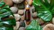 Bottle with essential oil on stones with leaves. Selective focus.