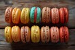 A row of vibrant macaroons arranged neatly on a rustic wooden table.