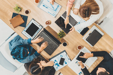 Wall Mural - Top view of businessman executive in group meeting with other businessmen and businesswomen in modern office with laptop computer, coffee and document on table. People corporate business team uds