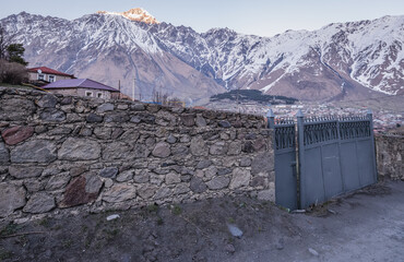 Wall Mural - Stone fence in Gergeti village near Stepantsminda, formerly Kazbegi. View with Mount Shani, Georgia