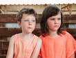 © ADDICTIVE STOCK - A boy and girl sit side by side against a wooden fence, lost in thought and taking in the sights of a farm school during summer