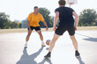 © Rob and Julia Campbell/Stocksy - Two men playing one-on-one basketball together outside.