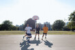 © Rob and Julia Campbell/Stocksy - A group of friends playing basketball together outside.
