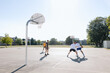 © Rob and Julia Campbell/Stocksy - A group of friends playing basketball together outside.