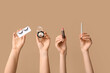 © Pixel-Shot - Female hands with cosmetics for eyes and lipstick on beige background