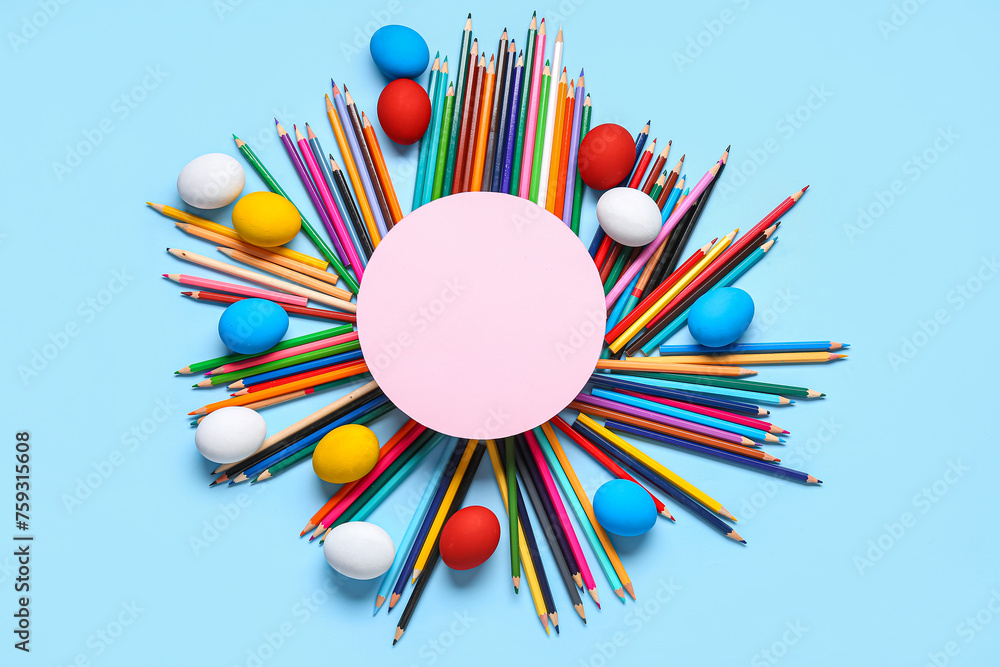 Frame made of Easter eggs, pencils and blank card on color background. Easter concept.