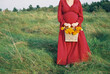 © Serena Burroughs/Stocksy - pregnant woman with bright red dress holding pretty marigolds
