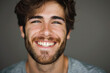 A man with a beard and freckles smiles for the camera