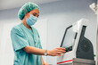 © VICTOR TORRES/Stocksy - Female doctor in scrubs using intraoperative neuromonitor in clinic
