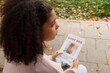 © Danil Nevsky/Stocksy - Black female sitting on bench with lost dog placard
