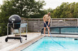 © Diego Martin/Stocksy - Teen cleaning pool with net