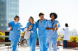 © BONNINSTUDIO/Stocksy - Medical team during conversation on hospital terrace