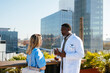 © BONNINSTUDIO/Stocksy - Medical team during conversation on hospital terrace