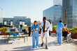 © BONNINSTUDIO/Stocksy - Medical team during conversation on hospital terrace