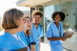 © BONNINSTUDIO/Stocksy - Medical team during conversation on hospital terrace