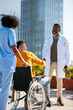 © BONNINSTUDIO/Stocksy - Doctor and man in wheelchair greeting each other in outdoors