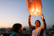 © Saptak Ganguly/Stocksy - Mother and son releasing sky lantern at twilight