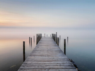  wooden pier at misty dawn in a still sea
