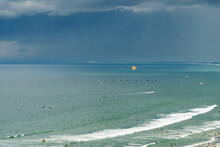 A Dark Stormy Sky Over A Calm Ocean Bay Full Of Swimmers And Boats At Da Nang In Vietnam