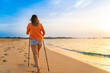 Nordic walking - beautiful woman exercising on tropical beach